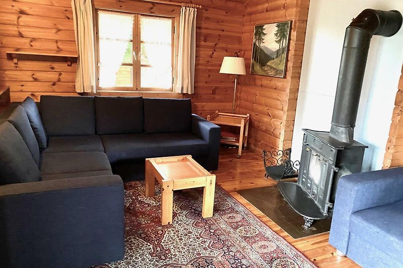 Bsp. Ferienhaus LTD 46 - Wohnzimmer mit Holzmöbeln und gemütlicher Beleuchtung.