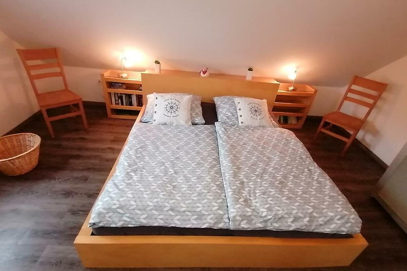 Großzügiges Schlafzimmer mit Doppelbett und Schiebetürenschrank