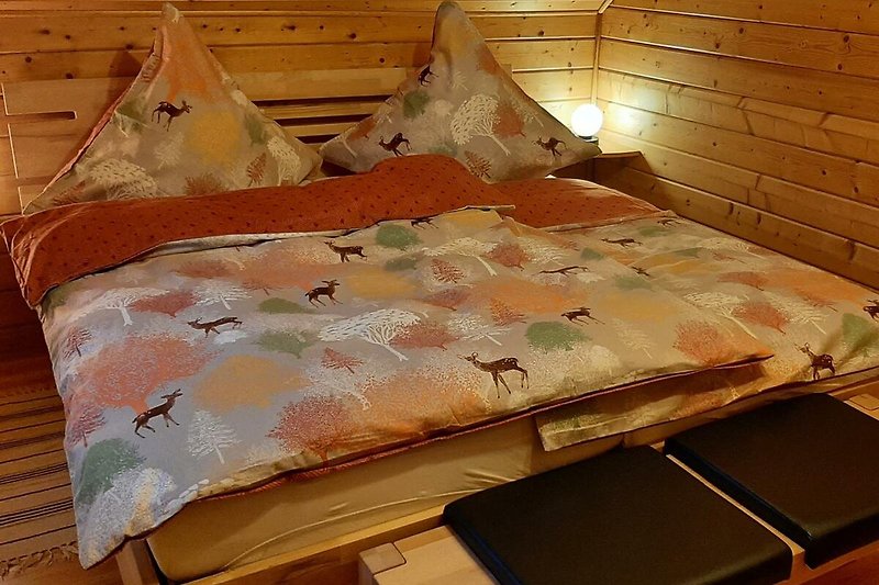 Gemütliches Schlafzimmer mit stilvollem Holzbett und gemütlicher Bettwäsche.