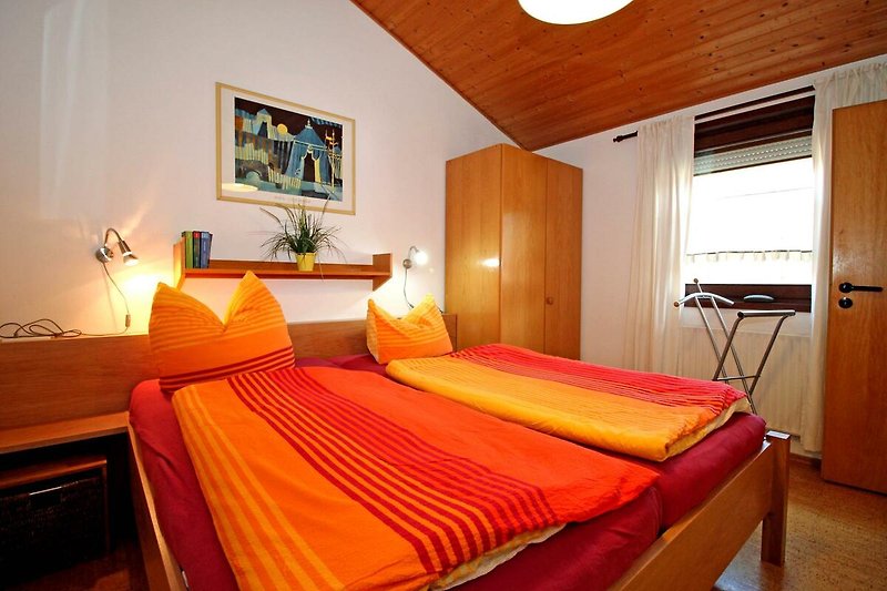 Gemütliches Schlafzimmer mit Holzmöbeln und warmem Licht.
