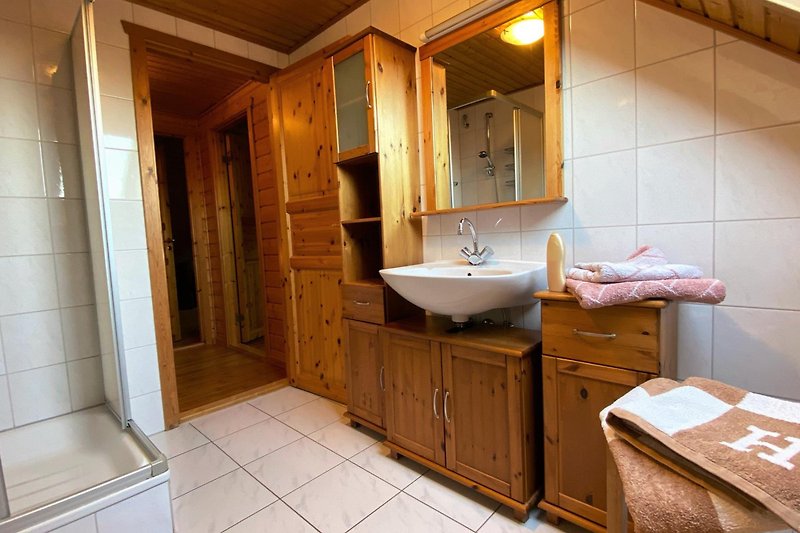 Gemütliches Badezimmer mit lila Akzenten, Spiegel und Waschbecken.