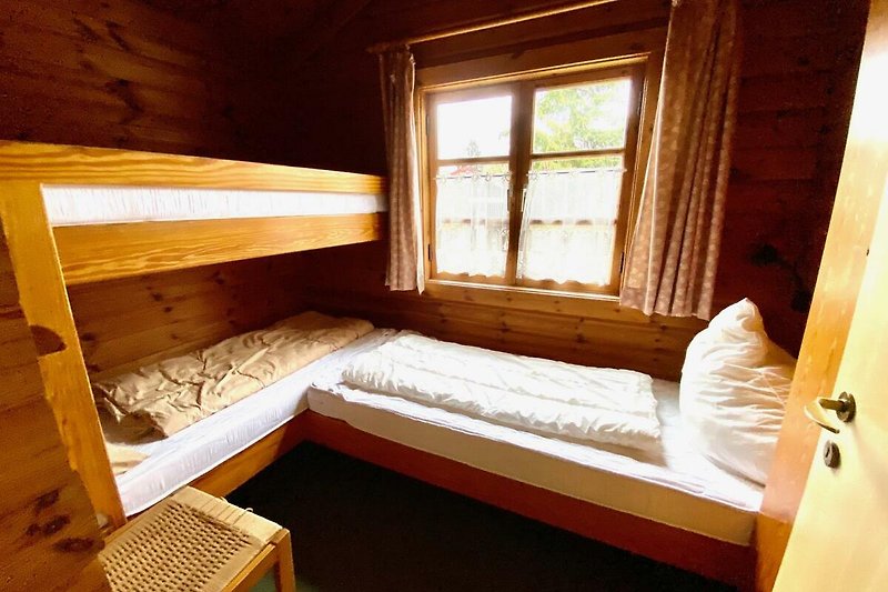 Bsp. Ferienhaus LTD 46 - Schlafzimmer mit Holzmöbeln.