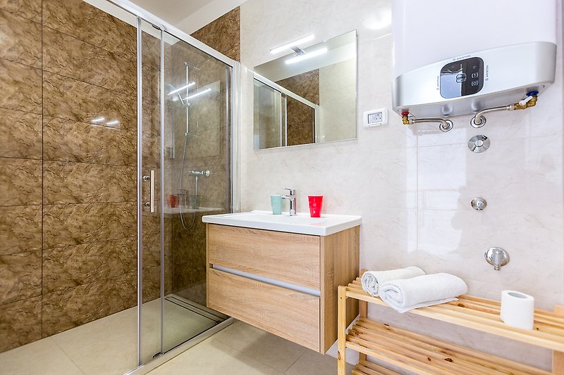 Stilvolles Badezimmer mit Spiegel, Waschbecken und stilvoller Einrichtung.