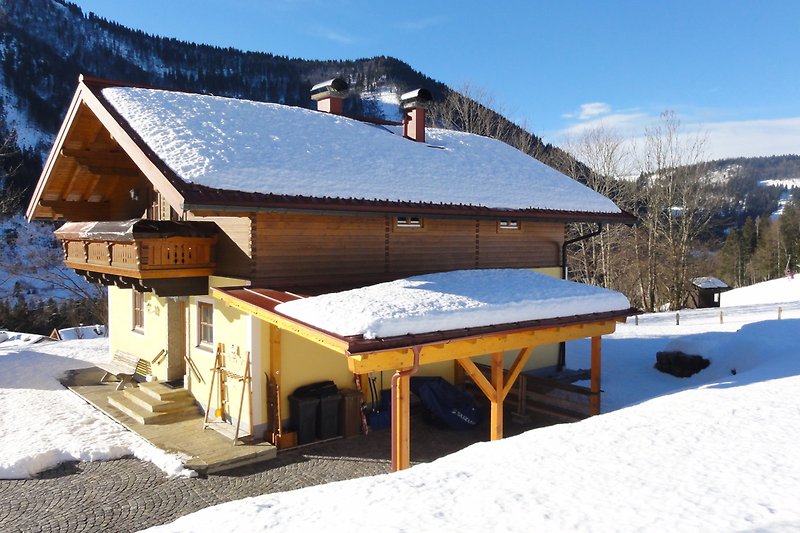 Gemütliches Holzhaus in den Alpen mit verschneiter Landschaft und Bergblick. Perfekt für Winterurlaub.