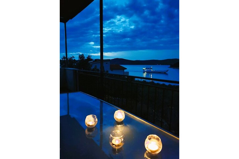 Romantische Aussicht in der Abenddämmerung von der Terrasse der Villa Marela, als die Fähre ankommt.
