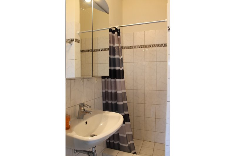 Schönes Badezimmer mit Fliesen, Spiegel und Marmor.