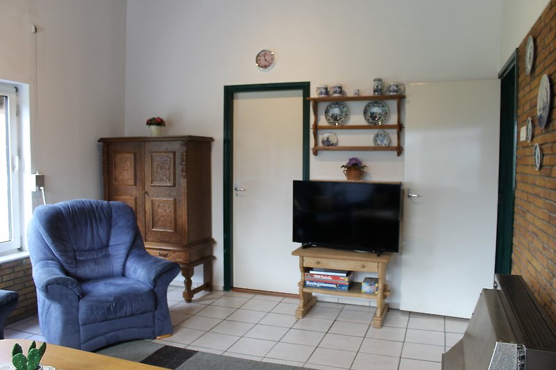 Gemütliches Wohnzimmer mit bequemer Couch, Holzmöbeln und Fernseher.