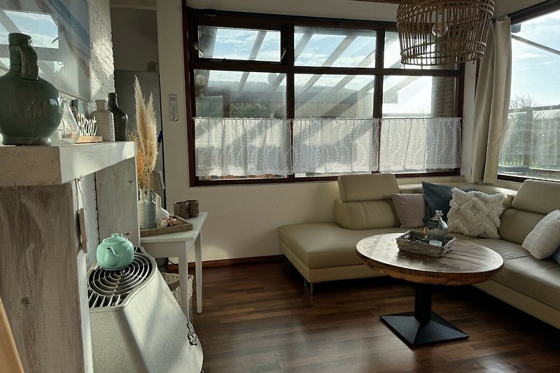 Wohnzimmer mit stilvoller Einrichtung, Holzmöbeln und Deckenlampe.