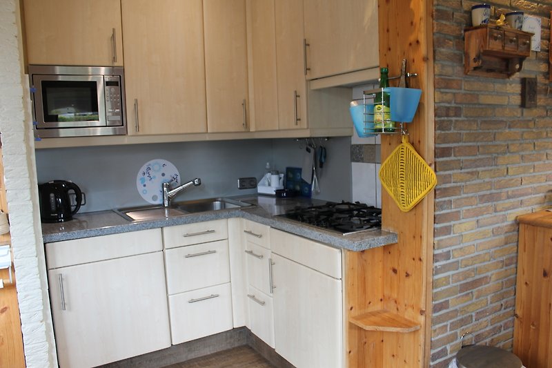 Moderne Küche mit Holzschränken, Arbeitsplatte und Gasherd.