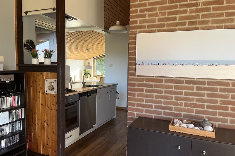 Moderne Küche mit Holzschränken, Arbeitsplatte und Küchengeräten.