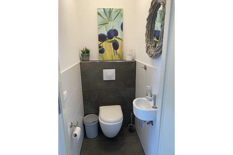 Schönes Badezimmer mit lila Akzenten, Spiegel und modernen Armaturen.