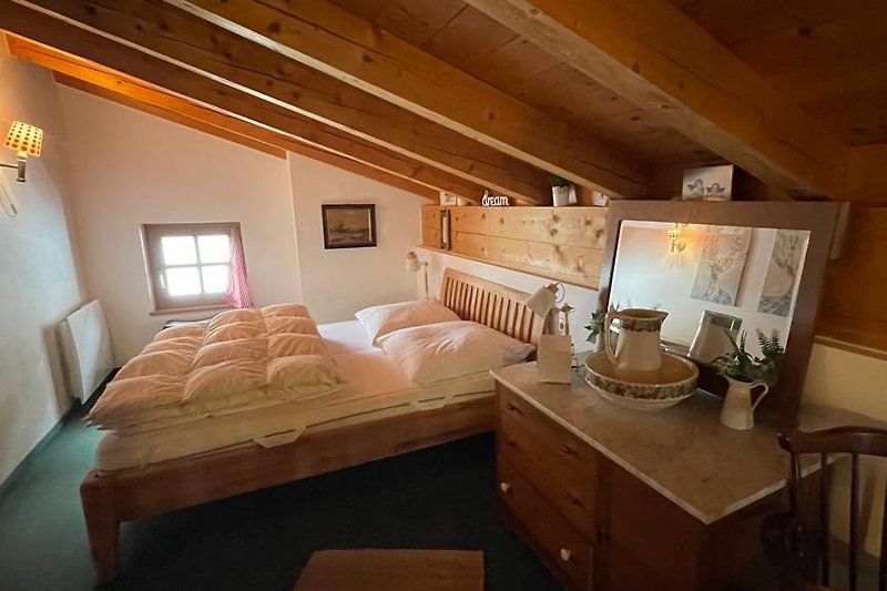 Gemütliches Schlafzimmer mit Holzbett 160x200 im OG und stilvoller Einrichtung.
