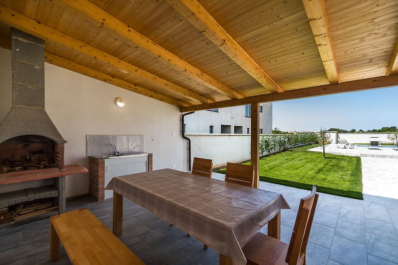 Rustikales Holzhaus mit gemütlicher Veranda und grüner Pflanze.