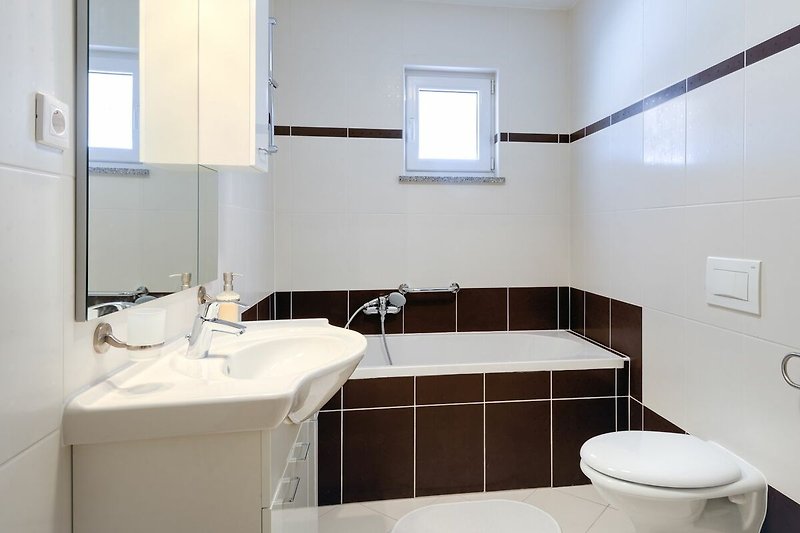 Ein modernes Badezimmer mit Spüle, Wasserhahn und Spiegel.