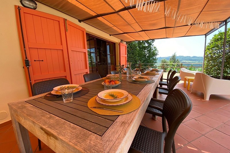 Gemütliche Terrasse mit Holzmöbeln und Blick auf den Garten.