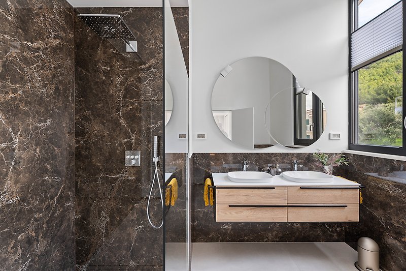 Modernes Badezimmer mit Spiegel, Waschbecken und Fensterblick.