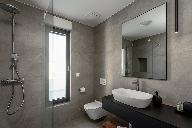 En-suite bathroom with a shower, and amazing views of the sea.