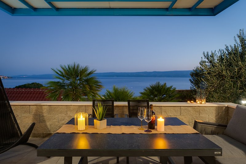 Outdoor dining area in the sunset, with sea and island views