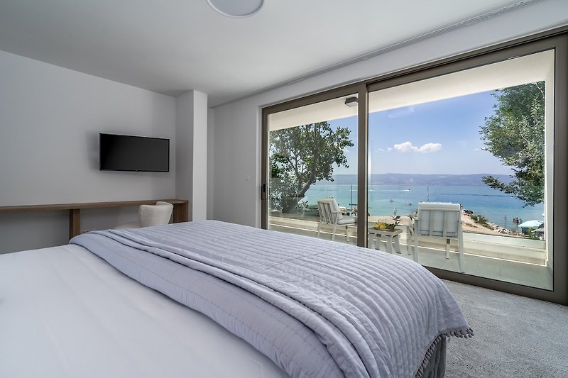 Bedroom No2 (South, 26sqm) offering amazing sea and pool views, with a King size bed 200cm x 200cm, a TV