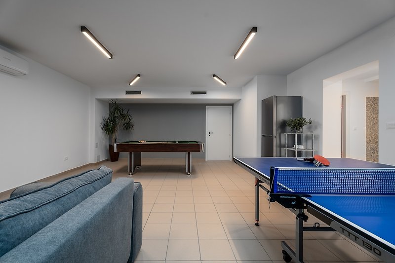 Spielbereich mit Sofa, PlayStation 4, JBL-Lautsprecher, Billard (Billardtisch), Tischtennis und einem Kühlschrank für Er
