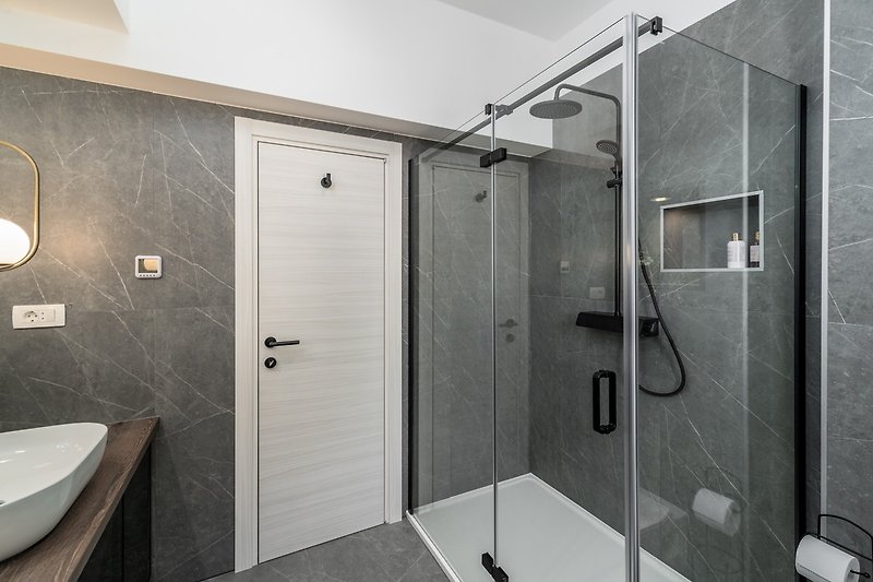 A Family bathroom with a shower, a double sink, and a toilet