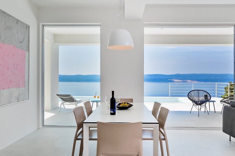 Dining area with opened sea views and exit to pool area 