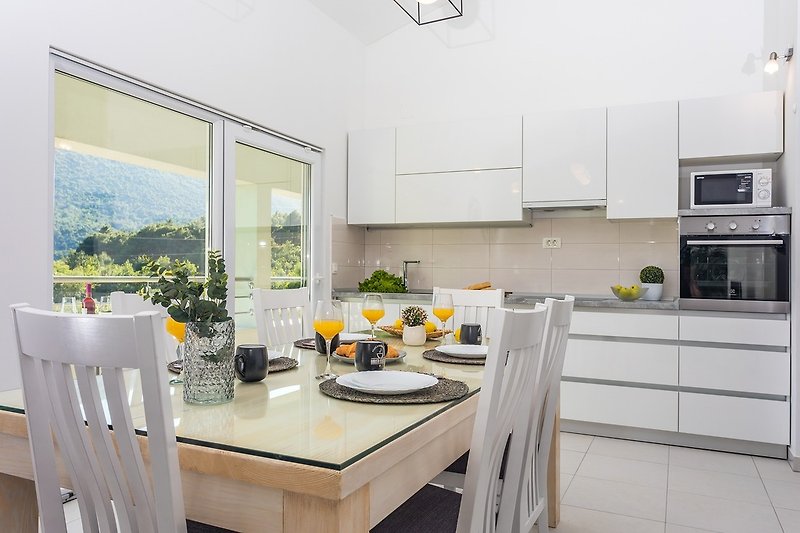 Voll ausgestattete Küche mit Ess- und Wohnbereich und Ausgang zur Terrasse