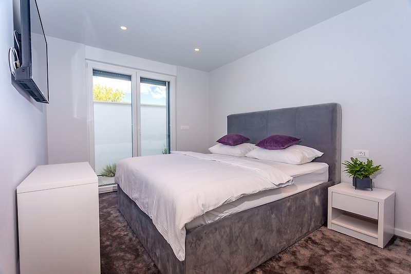 Schlafzimmer Nr. 1 mit einem Kingsize-Bett 180 cm x 200 cm, Klimaanlage, TV und Ausgang zur Terrasse.