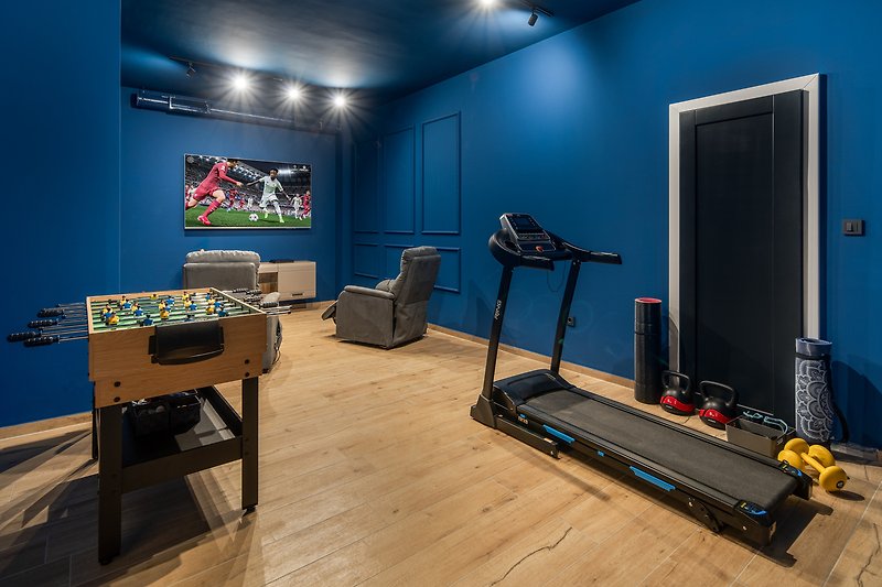 28 m2 großes Spielzimmer mit Sofas und PlayStation 4, und zum Trainieren gibt es ein Laufband, Yogamatten