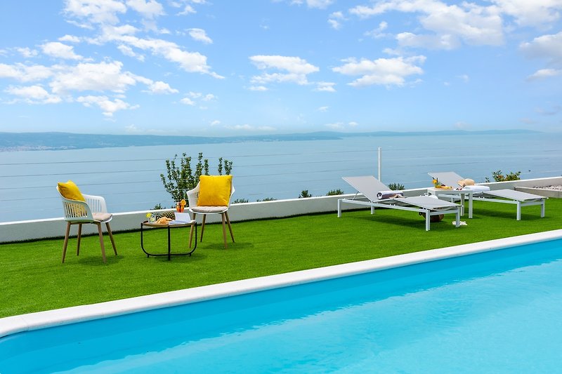 Ein privater Pool von 9 x 3,7 m, eine Sonnenterrasse mit Kunstrasen und 4 Liegestühlen