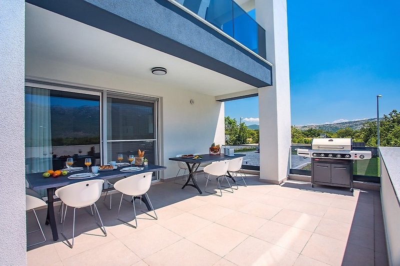 Outdoor dining area with a BBQ and a pool view (ground floor)