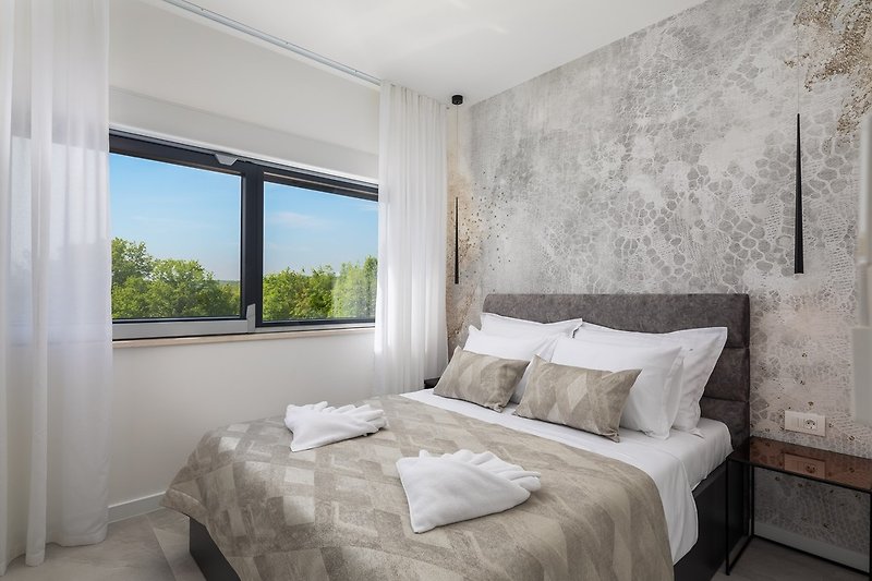 Schlafzimmer Nr. 2 (10,5 m²) mit einem Queensize-Bett (160 cm x 200 cm), Klimaanlage, Fernseher und einem Familienbadezi