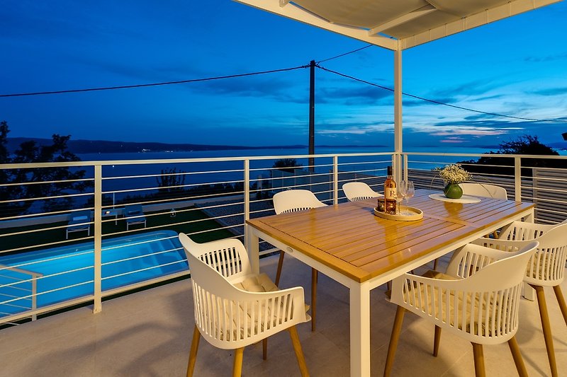 The outdoor dining area is next to the pool, with an amazing sea view.