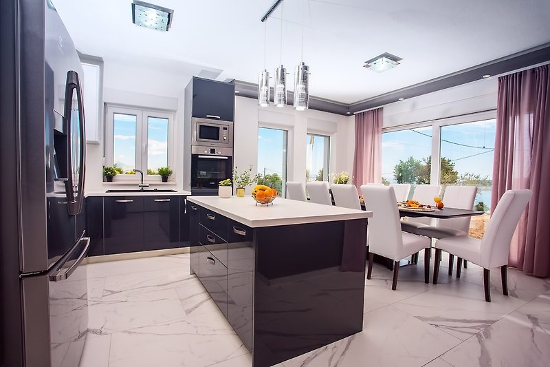 fully equipped kitchen with dining area and sea view