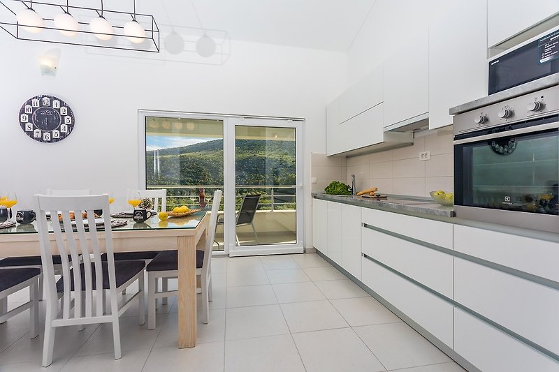 Fully equipped kitchen with dining & living area and exit to terrace