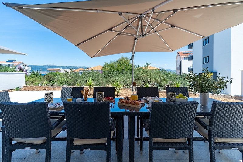 Spacious sun deck area with 10 deck chairs, an outdoor shower, a dining table and 2 sun umbrellas
