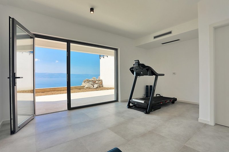  A few steps down behind the pool takes you to the gym with a pilates ball, treadmill