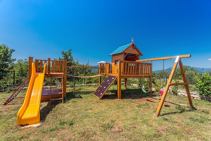 Kids playground with swing, wooden house and slide