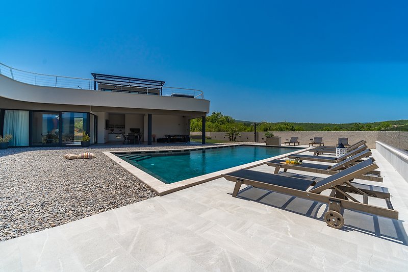 Luxury villa with swimming pool, stunning views, and modern interior design.