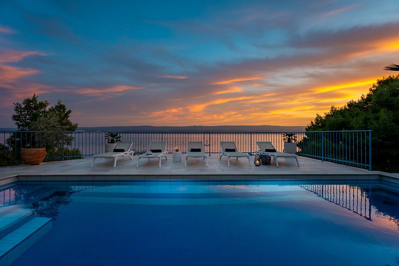 Atemberaubender Blick auf den Sonnenuntergang neben dem Poolbereich