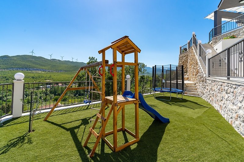 The outdoor area also offers a playground with a slide, a swing and some toys