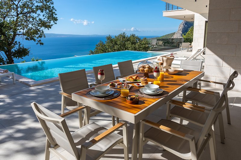 Relaxing outdoor dining with ocean view and comfortable furniture.