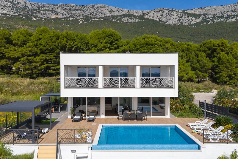 Elegante Villa mit Pool, Bergblick und stilvollen Möbeln.