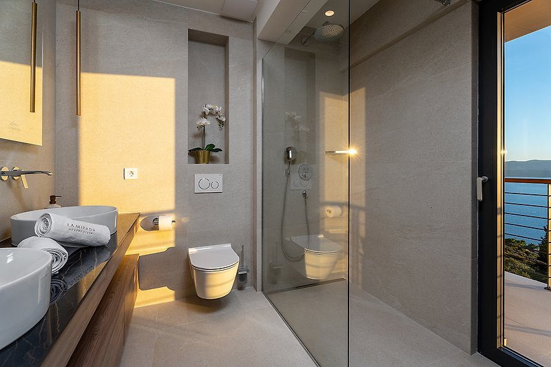 A modern bathroom with a stylish mirror, comfortable fixtures, and elegant flooring.