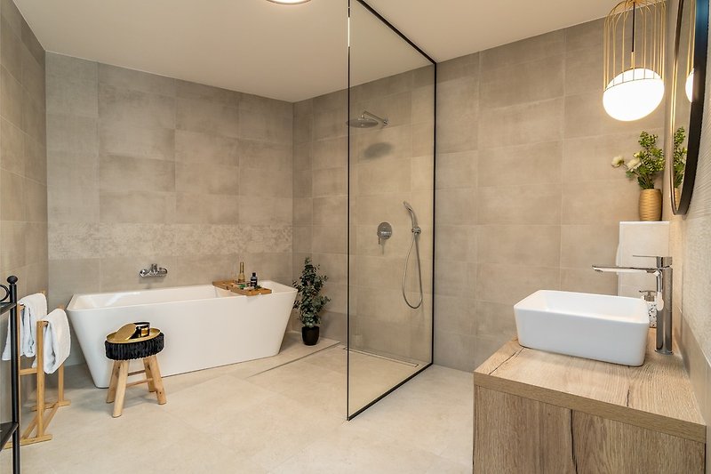An en-suite bathroom with a bathtub, a shower, a sink, and a toilet