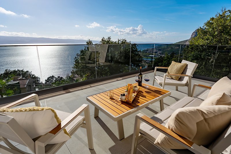 A cozy outdoor seating area with comfortable furniture and a beautiful ocean view.