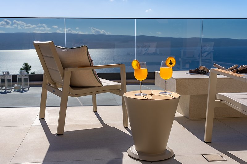 Comfortable outdoor seating with ocean view and stylish furniture.