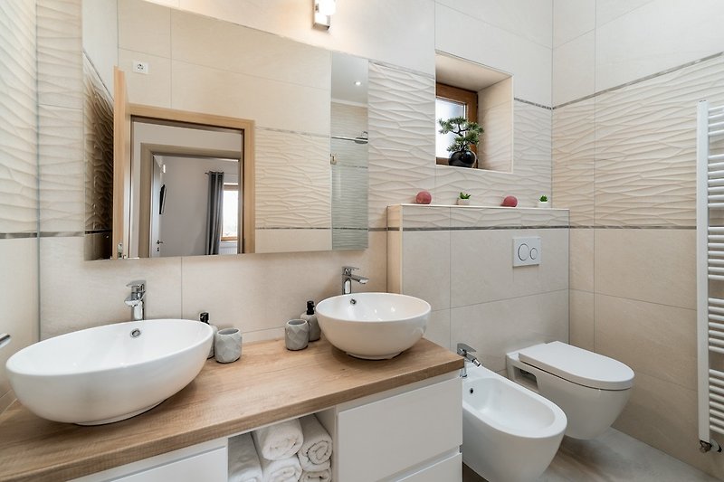 A family bathroom with a shower, toilet, bidet.