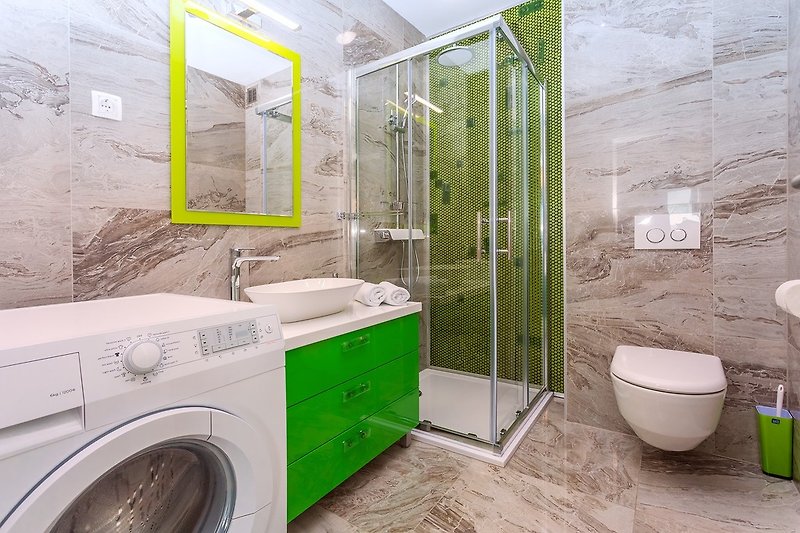 Ein Familienbadezimmer mit Dusche und Waschmaschine