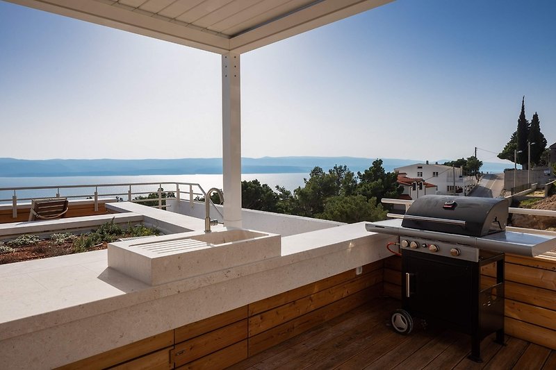 A rooftop area (93 sqm) approachable by elevator or a staircase offers a barbecue, a kitchenette with a fridge.